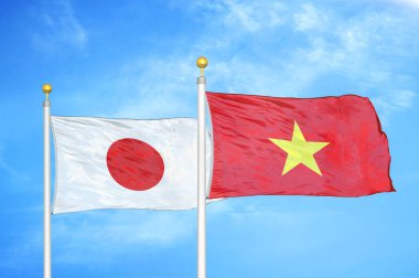 Japonya ve Vietnam bayrak direkleri üzerinde iki bayrak ve mavi bulutlu arka plan
