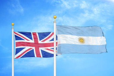 Birleşik Krallık ve Arjantin bayrak direkleri üzerinde iki bayrak ve mavi bulutlu arka plan