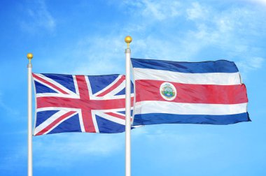 Birleşik Krallık ve Kosta Rika bayrak direkleri ve mavi bulutlu arka planda iki bayrak