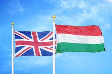 Birleşik Krallık ve Macaristan bayrak direkleri ve mavi bulutlu arka planda iki bayrak