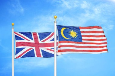 Birleşik Krallık ve Malezya bayrak direkleri ve mavi bulutlu arka planda iki bayrak