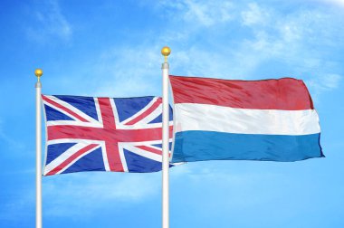 Birleşik Krallık ve Hollanda bayrak direkleri ve mavi bulutlu arka planda iki bayrak