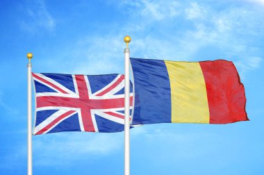 İngiltere ve Romanya bayrak direkleri ve mavi bulutlu arka planda iki bayrak