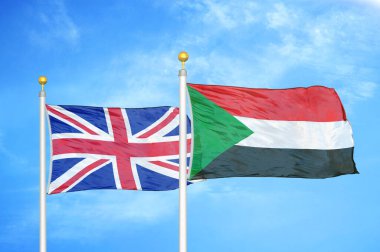 Birleşik Krallık ve Sudan bayrak direkleri üzerinde iki bayrak ve mavi bulutlu arka plan