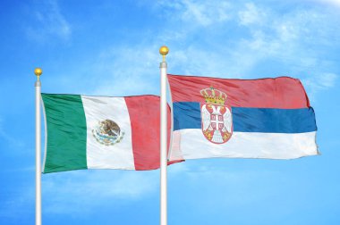 Meksika ve Sırbistan bayrak direkleri ve mavi bulutlu arka planda iki bayrak