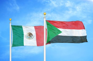 Meksika ve Sudan bayrak direkleri üzerinde iki bayrak ve mavi bulutlu arka plan