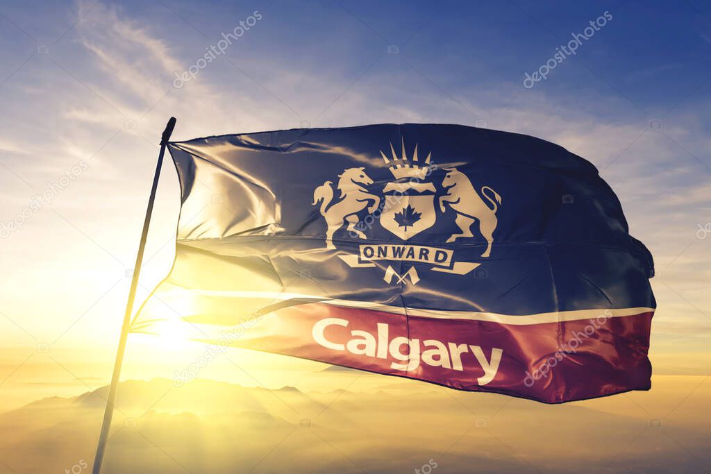 Calgary of Alberta of Canada flag textile cloth fabric waving on the top sunrise mist fog