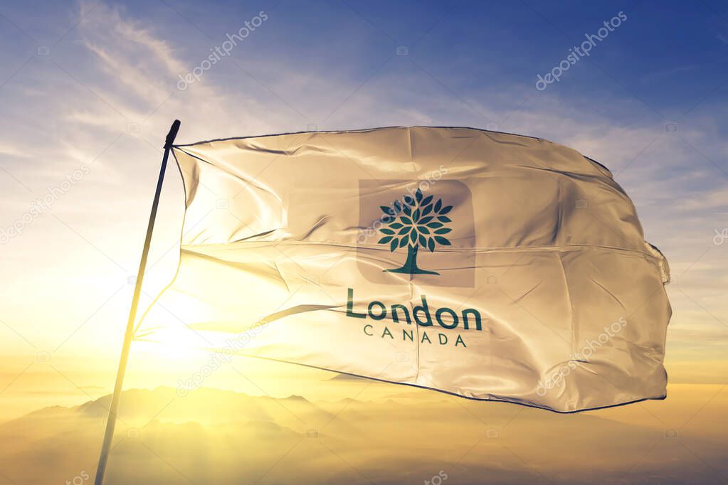 London of Ontario of Canada flag textile cloth fabric waving on the top sunrise mist fog