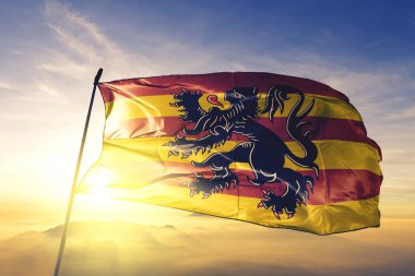 Walloon Brabant 'ın Oudenaarde' i Belçika bayrağı tekstil kumaşı en üstteki gün doğumu sisinde sallanıyor