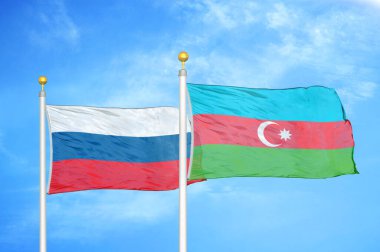 Rusya ve Azerbaycan bayrak direkleri ve mavi bulutlu arka planda iki bayrak