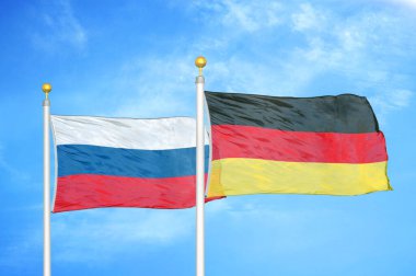 Rusya ve Almanya bayrak direkleri ve mavi bulutlu arka planda iki bayrak