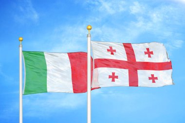 İtalya ve Gürcistan bayrak direkleri ve mavi bulutlu arka planda iki bayrak