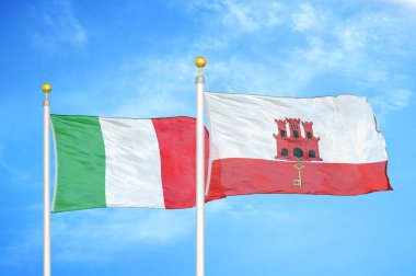 İtalya ve Cebelitarık bayrak direkleri ve mavi bulutlu arka planda iki bayrak