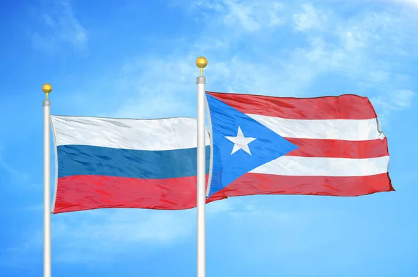 Rusko Portoriko Dvě Vlajky Vlajkových Stožárech Modrá Oblačná Obloha Pozadí — Stock fotografie