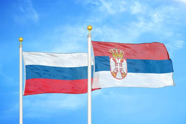 Rusko Srbsko Dvě Vlajky Vlajkových Stožárech Modrá Oblačná Obloha Pozadí — Stock fotografie