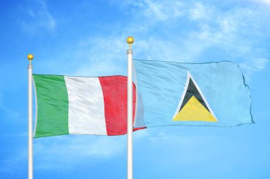 İtalya ve Saint Lucia bayrak direkleri ve mavi bulutlu arka planda iki bayrak