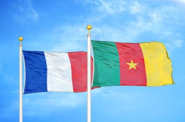 Fransa ve Kamerun bayrak direkleri ve mavi bulutlu arka planda iki bayrak