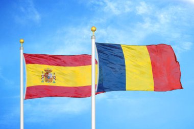 İspanya ve Çad bayrak direkleri üzerinde iki bayrak ve mavi bulutlu arka plan