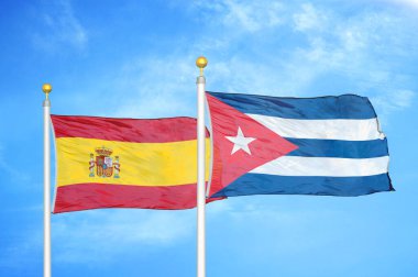İspanya ve Küba bayrak direkleri üzerinde iki bayrak ve mavi bulutlu arka plan