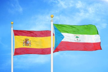 İspanya ve Ekvator Ginesi bayrak direkleri üzerinde iki bayrak ve mavi bulutlu gökyüzü arka planı