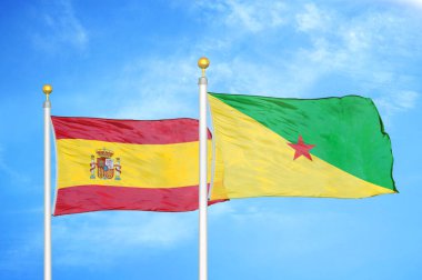 İspanya ve Fransız Guyanası bayrak direkleri ve mavi bulutlu arka planda iki bayrak