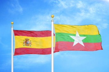 İspanya ve Myanmar bayrak direkleri ve mavi bulutlu arka planda iki bayrak
