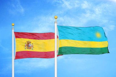 İspanya ve Ruanda bayrak direkleri ve mavi bulutlu arka planda iki bayrak