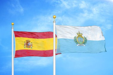 İspanya ve San Marino bayrak direkleri ve mavi bulutlu arka planda iki bayrak