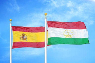 İspanya ve Tacikistan bayrak direkleri ve mavi bulutlu arka planda iki bayrak