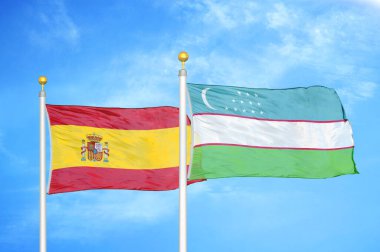 İspanya ve Özbekistan bayrak direkleri ve mavi bulutlu arka planda iki bayrak