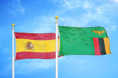 İspanya ve Zambiya bayrak direkleri üzerinde iki bayrak ve mavi bulutlu arka plan