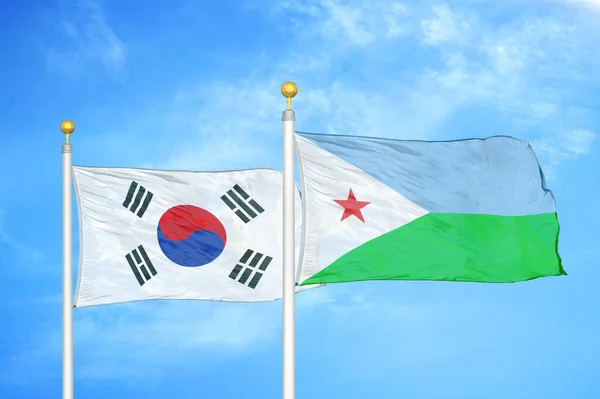 South Korea and Djibouti two flags on flagpoles and blue cloudy sky background