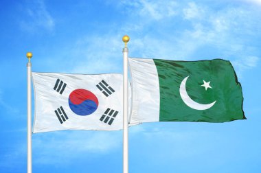 Güney Kore ve Pakistan bayrak direkleri ve mavi bulutlu arka planda iki bayrak