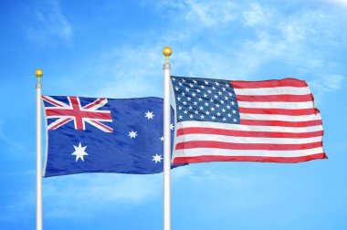 Avustralya ve ABD bayrak direkleri ve mavi bulutlu arka planda iki bayrak