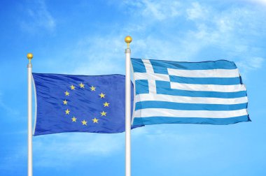 Avrupa Birliği ve Yunanistan bayrak direkleri ve mavi bulutlu arka planda iki bayrak
