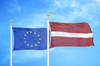 Avrupa Birliği ve Letonya bayrak direkleri ve mavi bulutlu arka planda iki bayrak