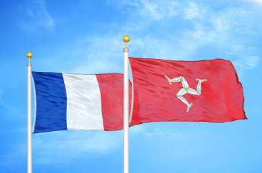 Fransa ve Mann Adası bayrak direkleri ve mavi bulutlu arka planda iki bayrak