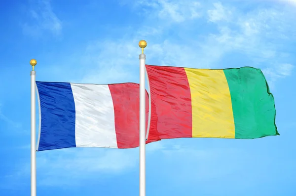 Γαλλία Και Γουινέα Δύο Σημαίες Κοντάρια Σημαίας Και Φόντο Μπλε — Φωτογραφία Αρχείου
