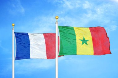 Fransa ve Senegal bayrak direkleri ve mavi bulutlu arka planda iki bayrak