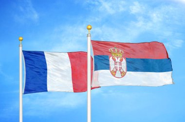 Fransa ve Sırbistan bayrak direkleri ve mavi bulutlu arka planda iki bayrak