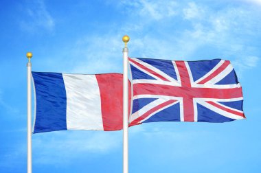 Fransa ve Birleşik Krallık bayrak direkleri ve mavi bulutlu arka planda iki bayrak
