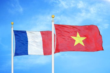 Fransa ve Vietnam bayrak direkleri üzerinde iki bayrak ve mavi bulutlu arka plan