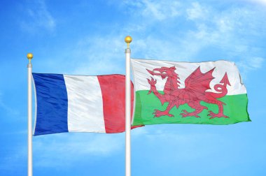 Fransa ve Galler bayrak direkleri ve mavi bulutlu arka planda iki bayrak