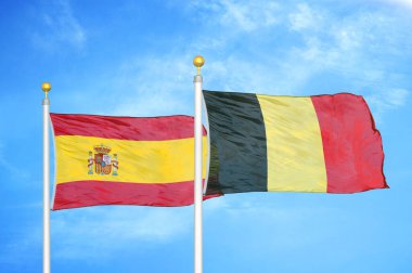 İspanya ve Belçika bayrak direkleri ve mavi bulutlu arka planda iki bayrak