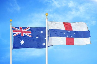 Avustralya ve Hollanda Antilleri bayrak direkleri ve mavi bulutlu arka planda iki bayrak