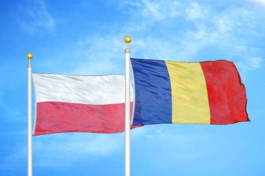 Polonya ve Romanya bayrak direkleri ve mavi bulutlu arka planda iki bayrak