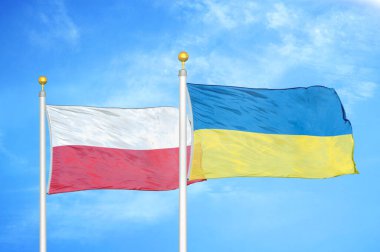 Polonya ve Ukrayna bayrak direkleri ve mavi bulutlu arka planda iki bayrak