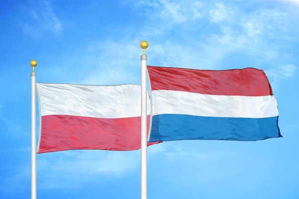ポーランドとオランダの旗竿と青空の背景に2つの旗 — ストック写真