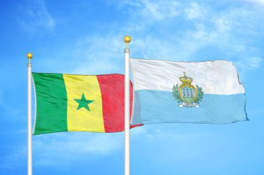 Senegal ve San Marino bayrak direkleri ve mavi bulutlu arka planda iki bayrak