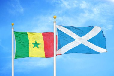 Senegal ve İskoçya bayrak direkleri ve mavi bulutlu arka planda iki bayrak